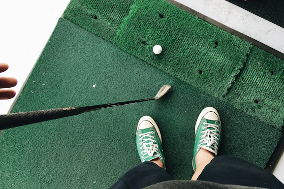 A friendly customer service representative holding a golf club, ready to assist with booking the mobile golf simulator.