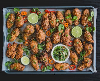 A sizzling plate of spicy chicken wings with vibrant sauces and fresh herbs.