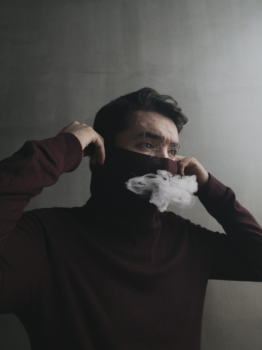man in brown sweater holding white tissue