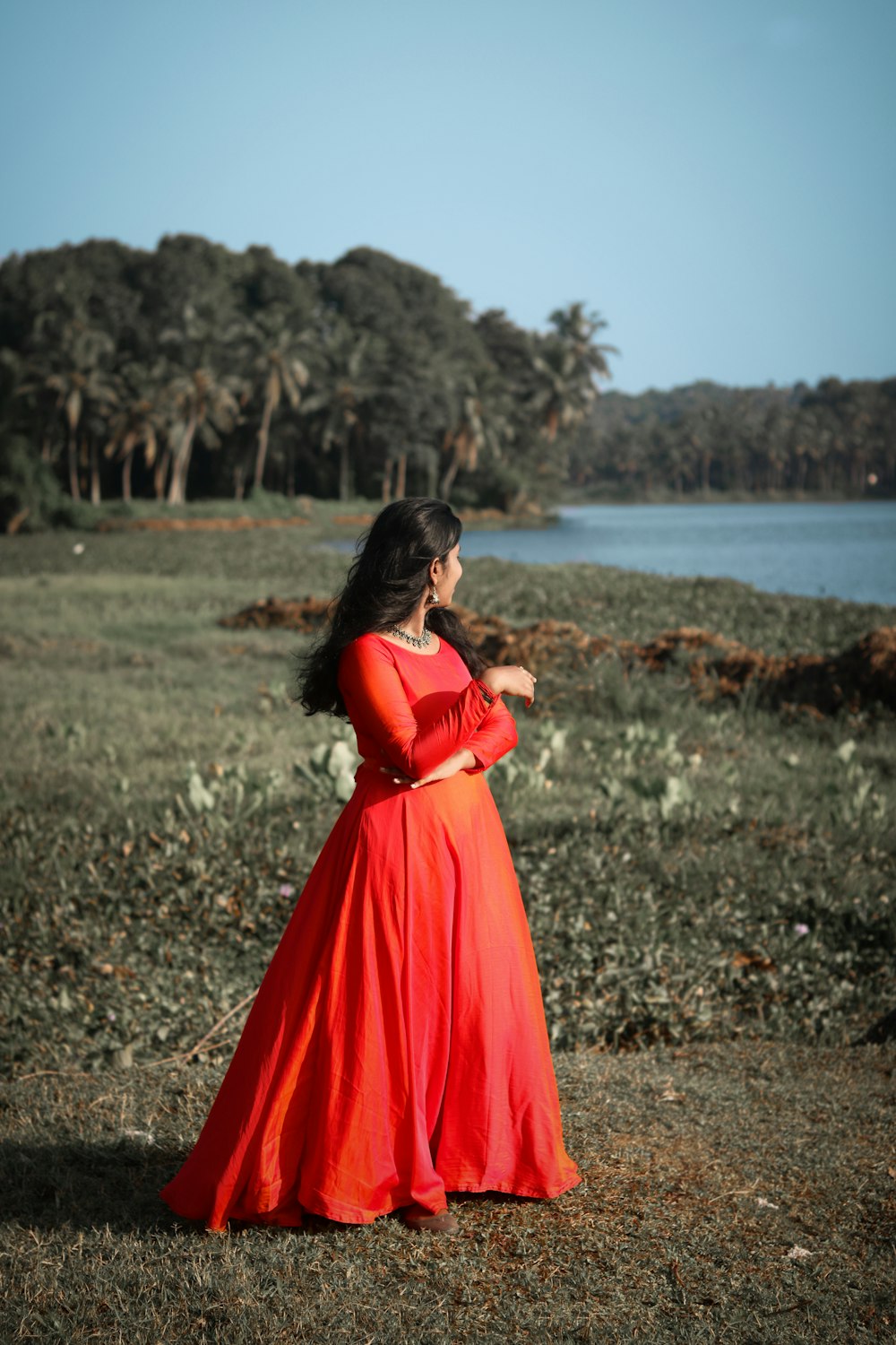 woman in red dress standing on ground during daytime
