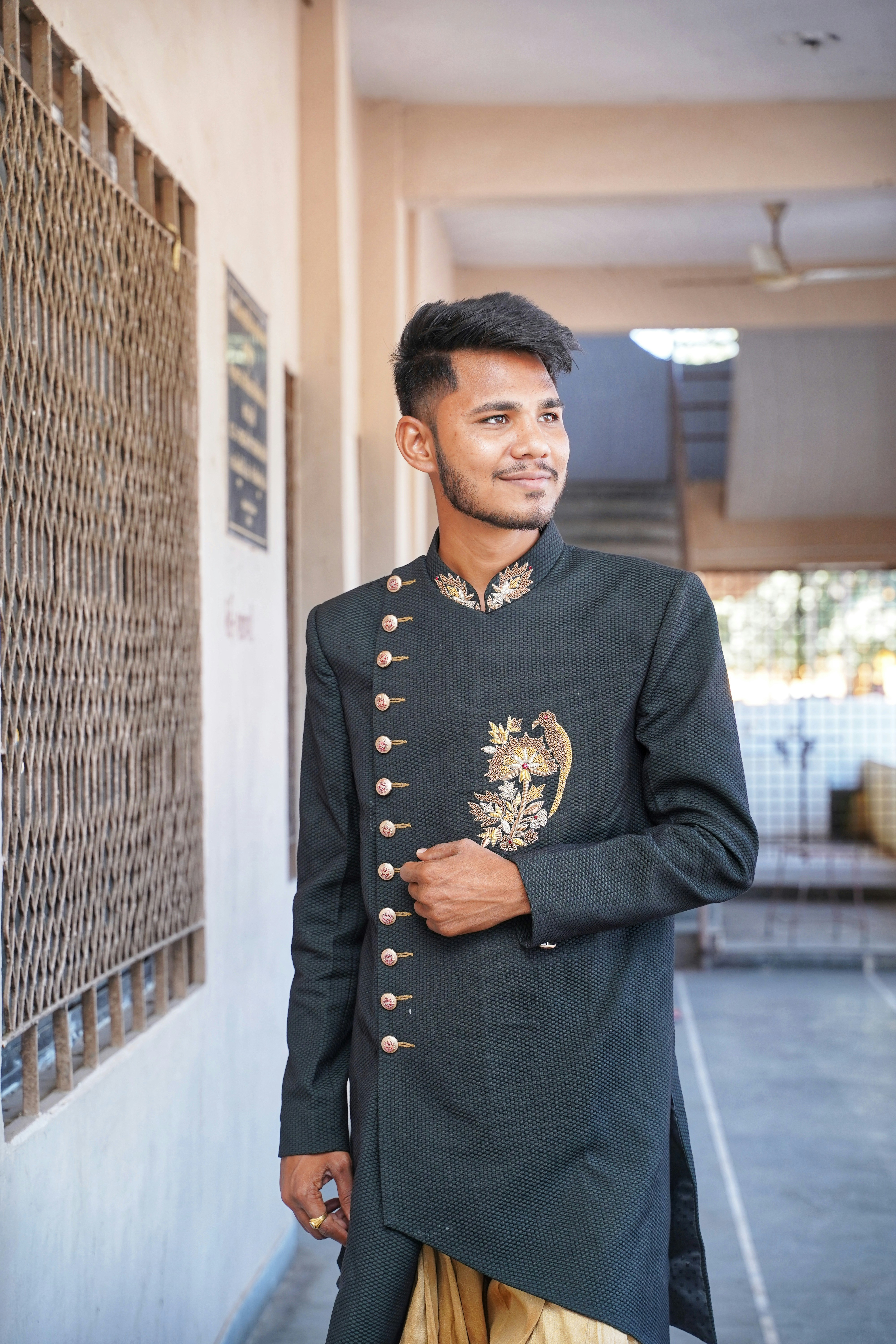 Man in embroidered sherwani walking down marble corridor, bright airy palace interior, natural light
