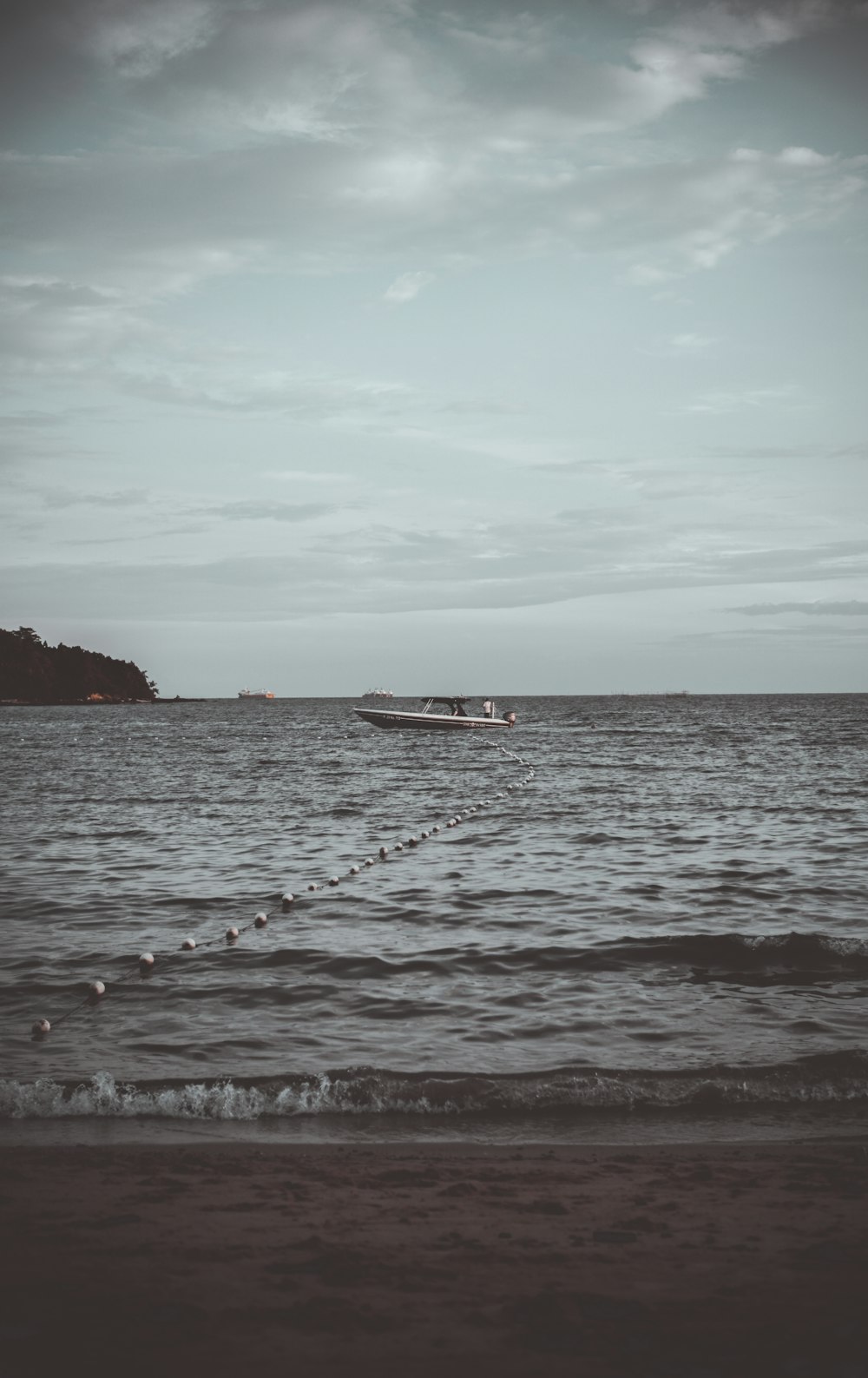 white boat on sea under white clouds during daytime