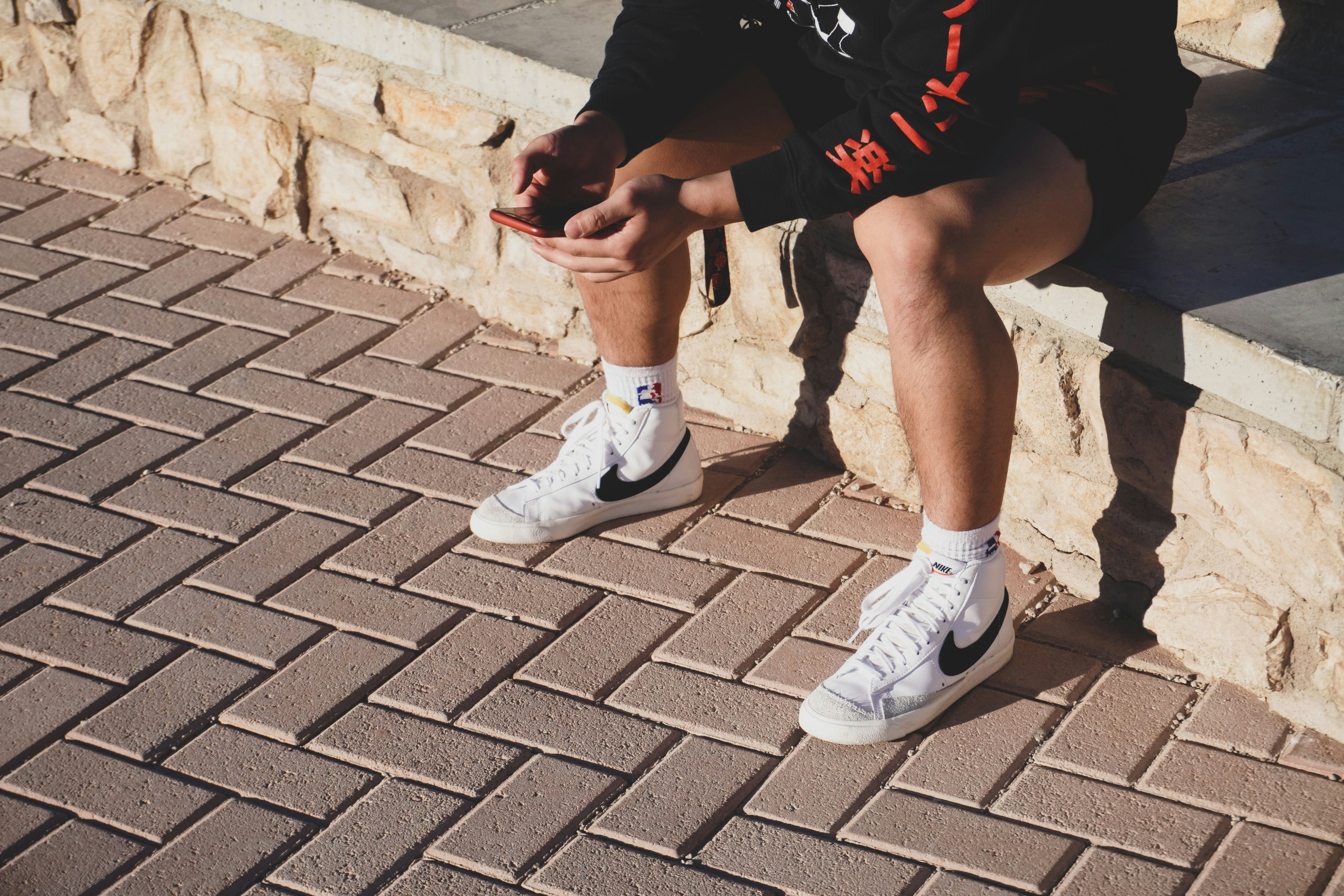 person in black shorts and white nike sneakers