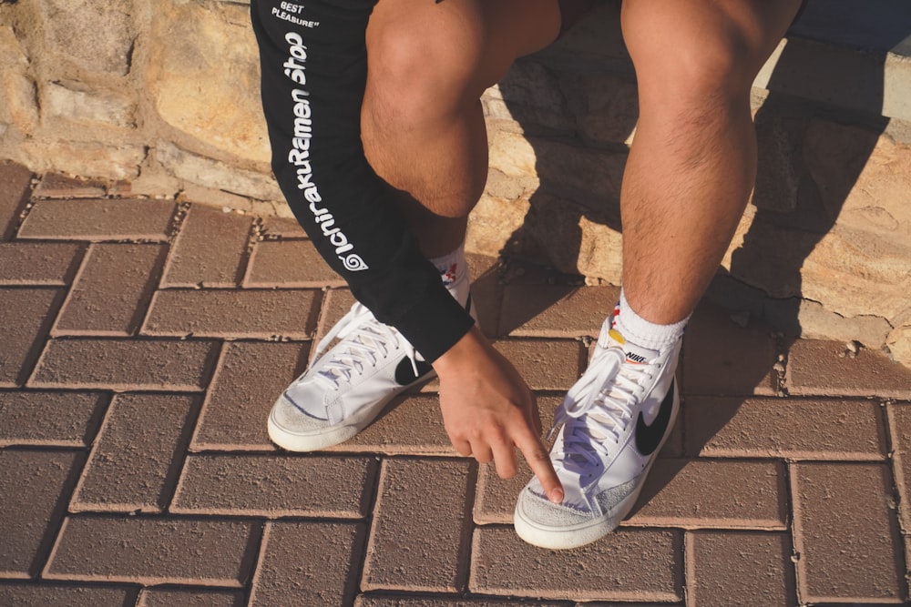 Foto Persona con pantalones cortos negros y zapatillas Nike blancas –  Imagen Ropa gratis en Unsplash