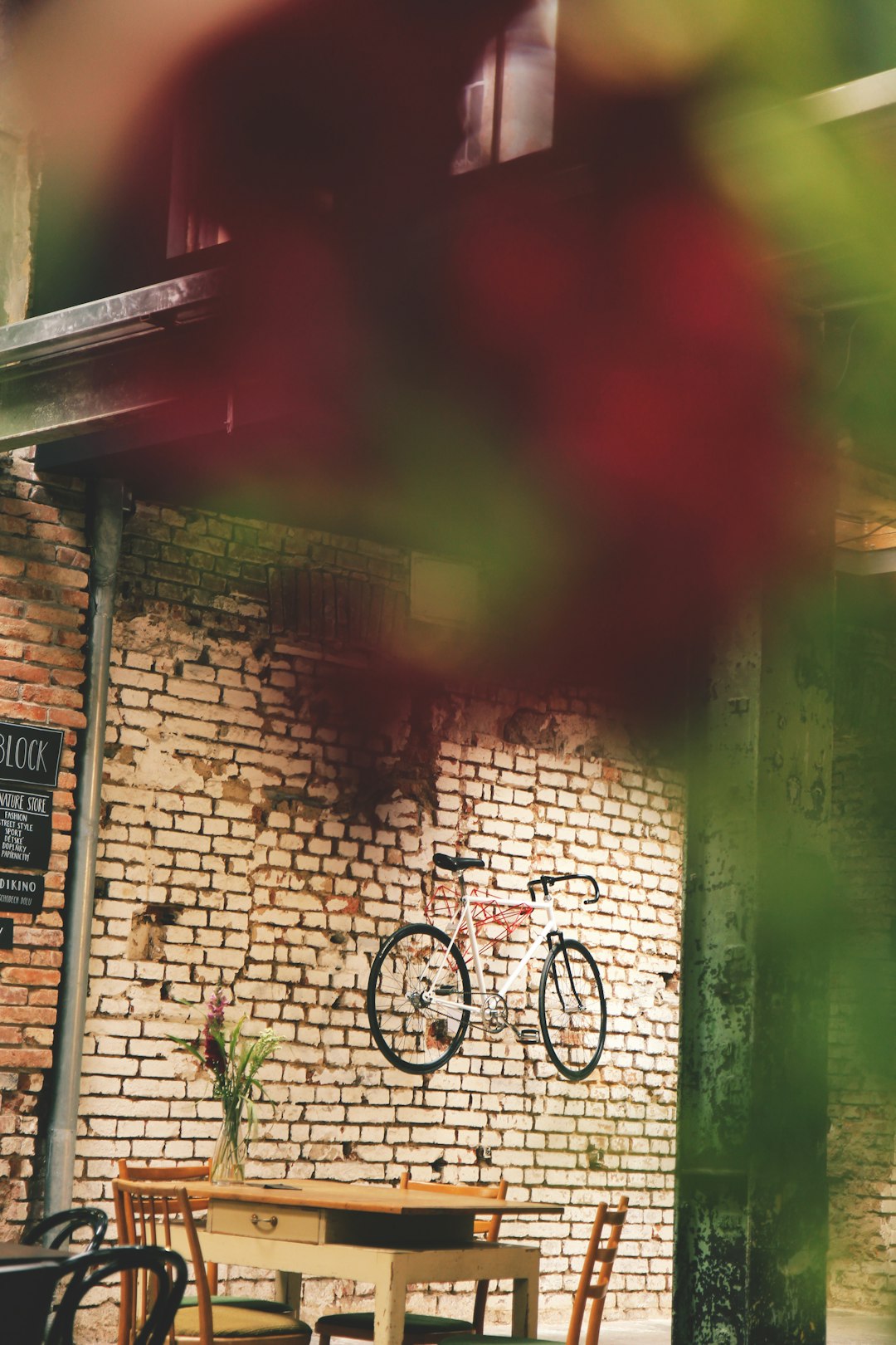 black bicycle parked beside brown brick wall