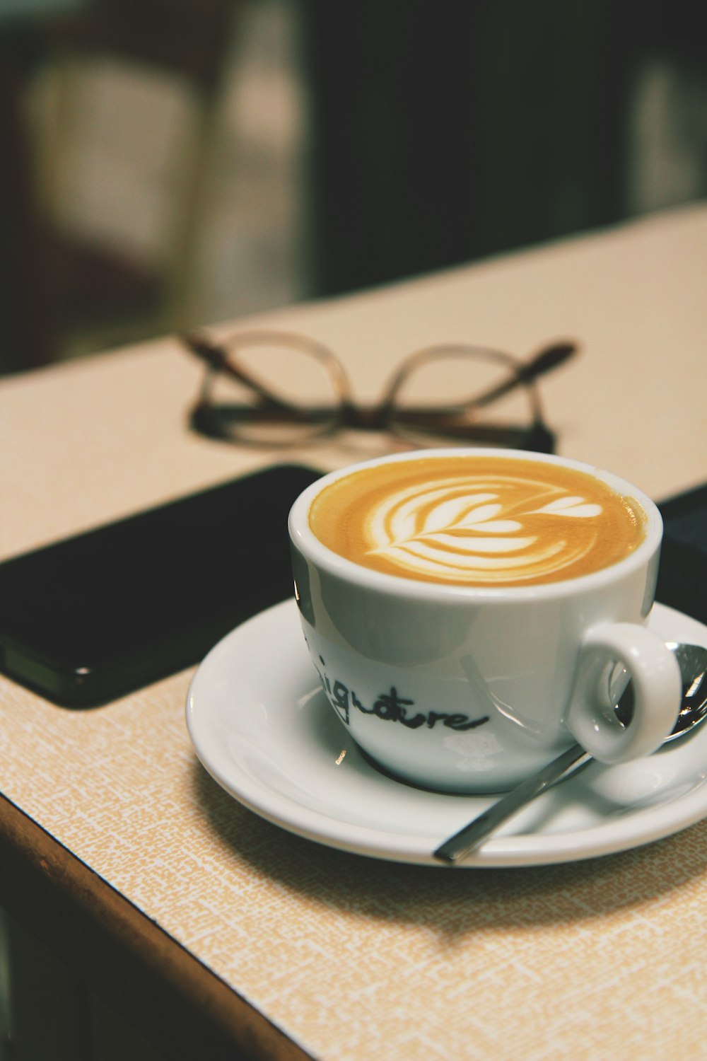 white ceramic cup with saucer on brown wooden table