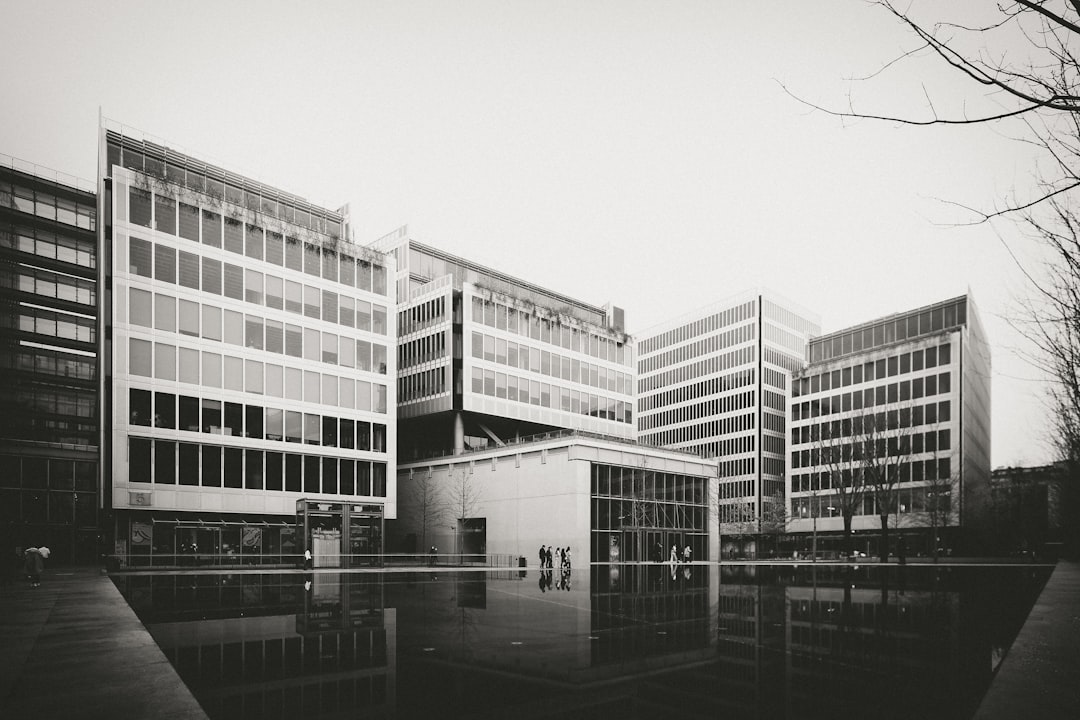 grayscale photo of building near body of water