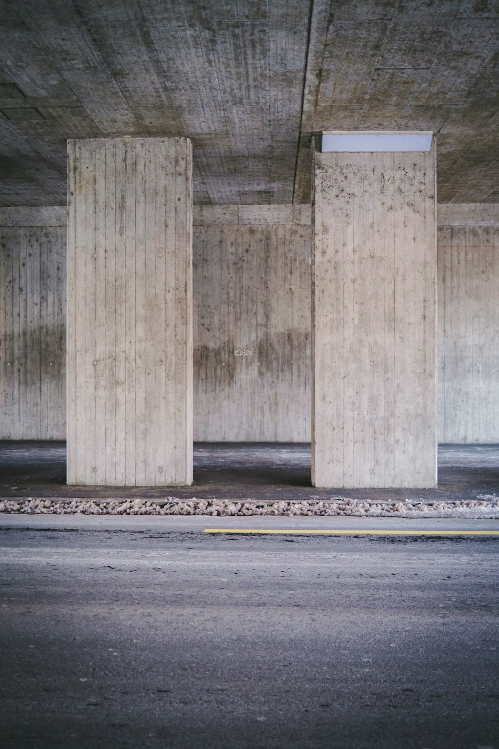 낮 동안 회색 아스팔트 도로에 회색 콘크리트 기둥