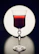 Sophisticated wine glass filled with deep red wine, set against a minimalist dark backdrop.