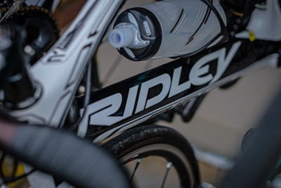 Close-up of cycling gloves and water bottles branded with Franklin Youth Cycling logos.