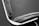 A close-up of a modern chair featuring black leather upholstery with visible stitches and a metallic frame. The image highlights the sleek lines and minimalist design of the chair against a plain background.