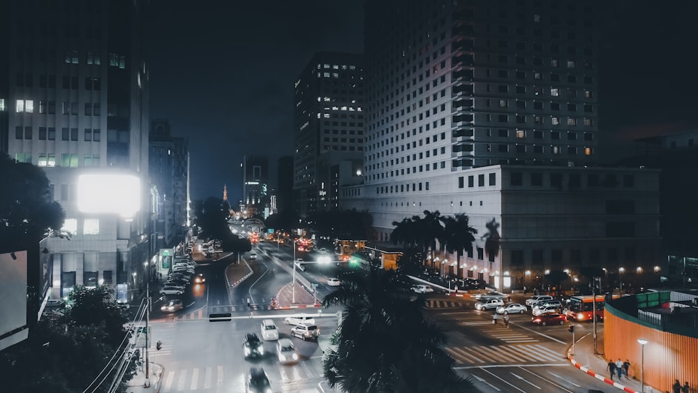 Coches en la carretera cerca de edificios de gran altura durante la noche