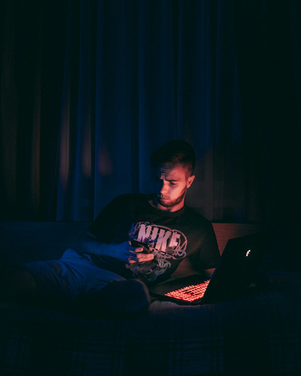 man in black crew neck t-shirt sitting on black sofa