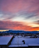 Sunrise paints colorful hues over a snowy alpine village