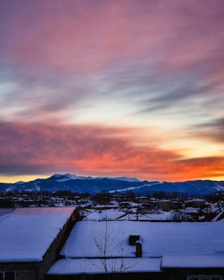 Sunrise paints colorful hues over a snowy alpine village