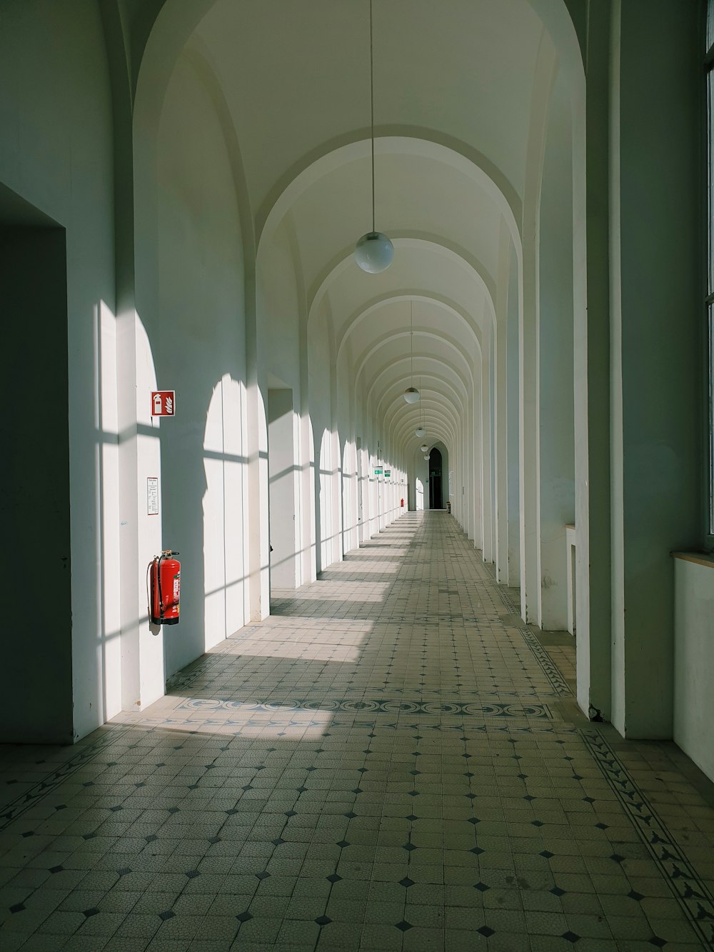 corredor de concreto branco com sinalização vermelha e branca