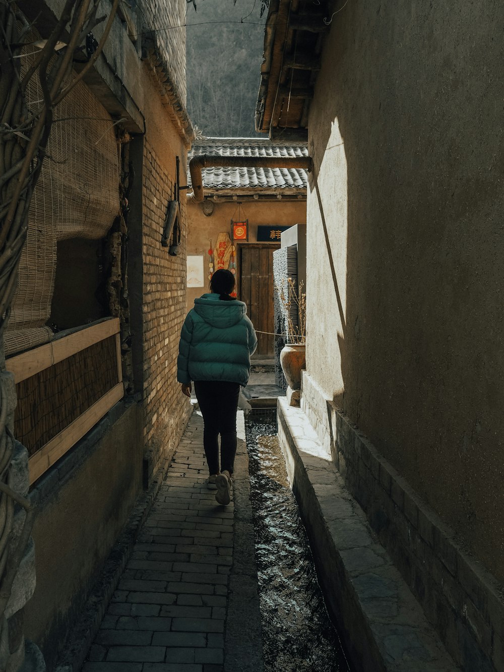 woman in green jacket walking on hallway