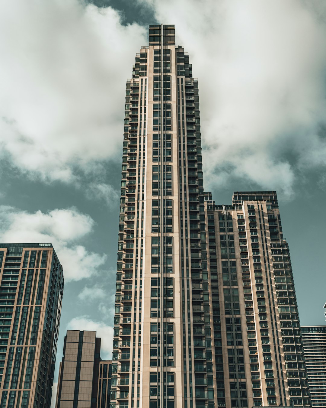 brown and black high rise building under gray clouds