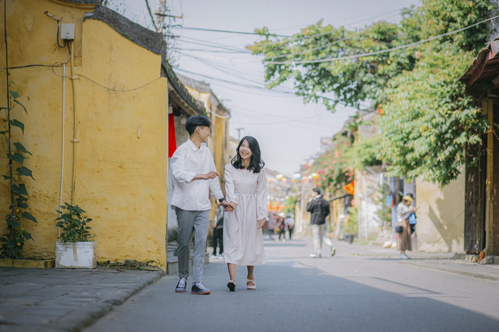 woman in white dress standing on sidewalk during daytime