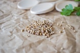 Fresh coriander seeds spread out on a clean white surface.