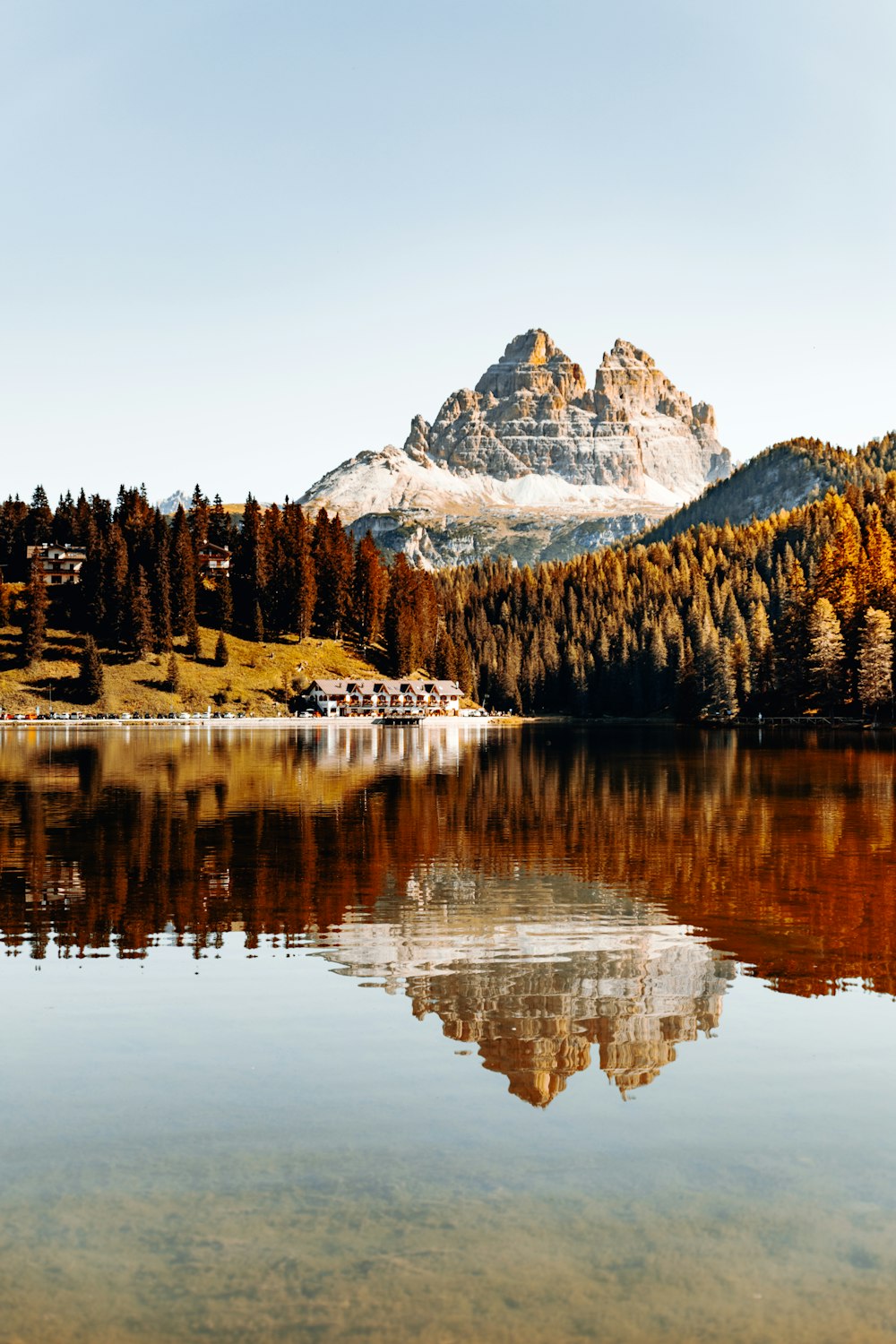 lake surrounded by trees and snow covered mountain during daytime