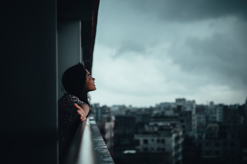 woman in black and white floral dress looking at city buildings during daytime