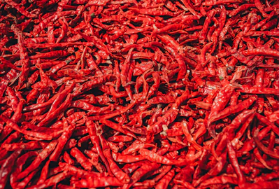 Close-up of vibrant dry red chilies piled in a rustic basket.