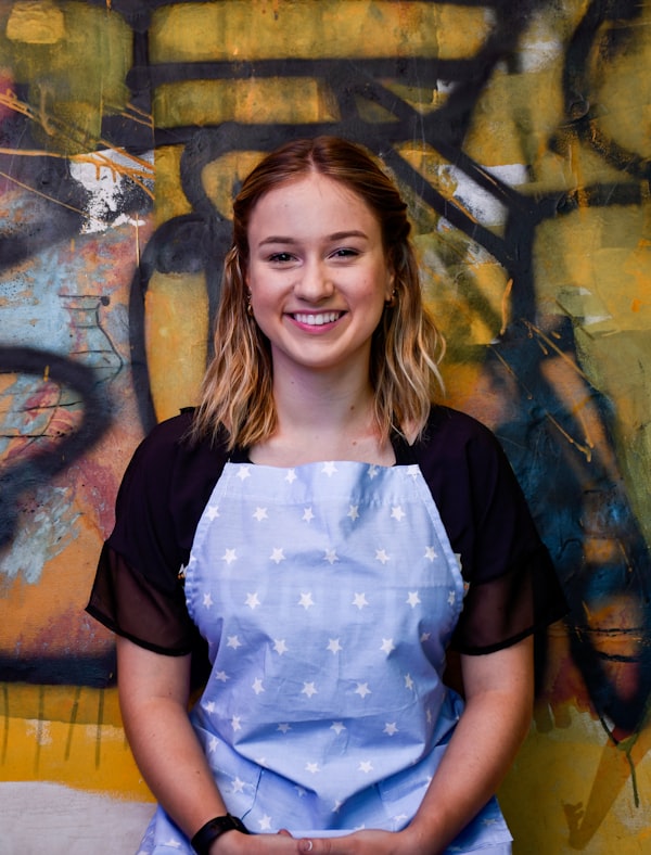 Sam Parke, certified master groomer, smiling in her grooming apron