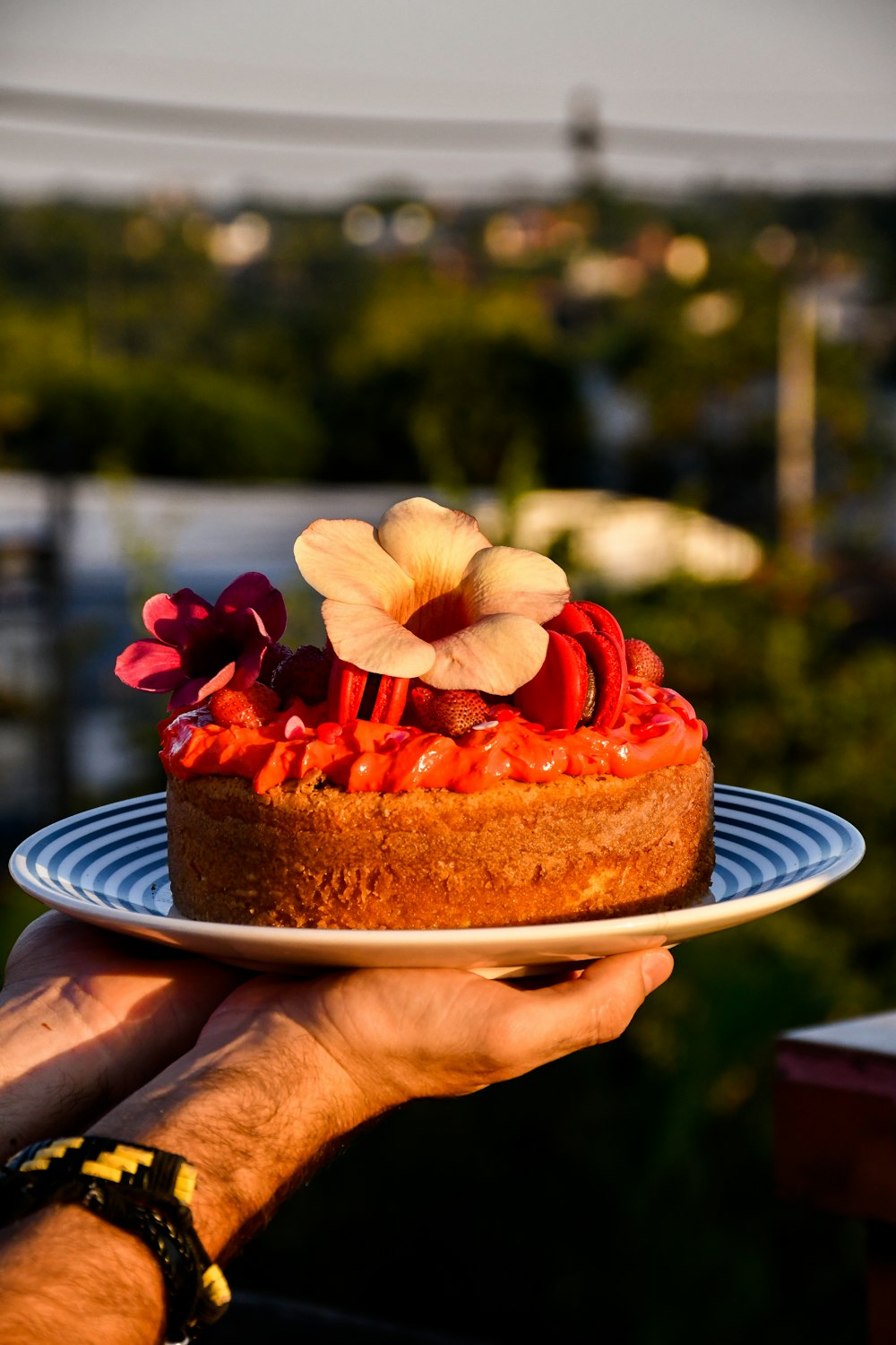 person holding sliced of cake with strawberry on top
