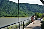 woman in black tank top and black shorts walking on wooden bridge during daytime