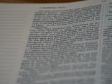 A close-up shot of a page from a book featuring text in a two-column layout. The text is clearly printed and slightly angled, with surrounding columns partially visible.