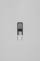 Elegant, minimalist wooden chair with matte black accents in a bright studio.