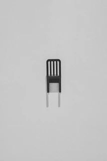 Minimalist shot of a single chair casting a long shadow on a white floor