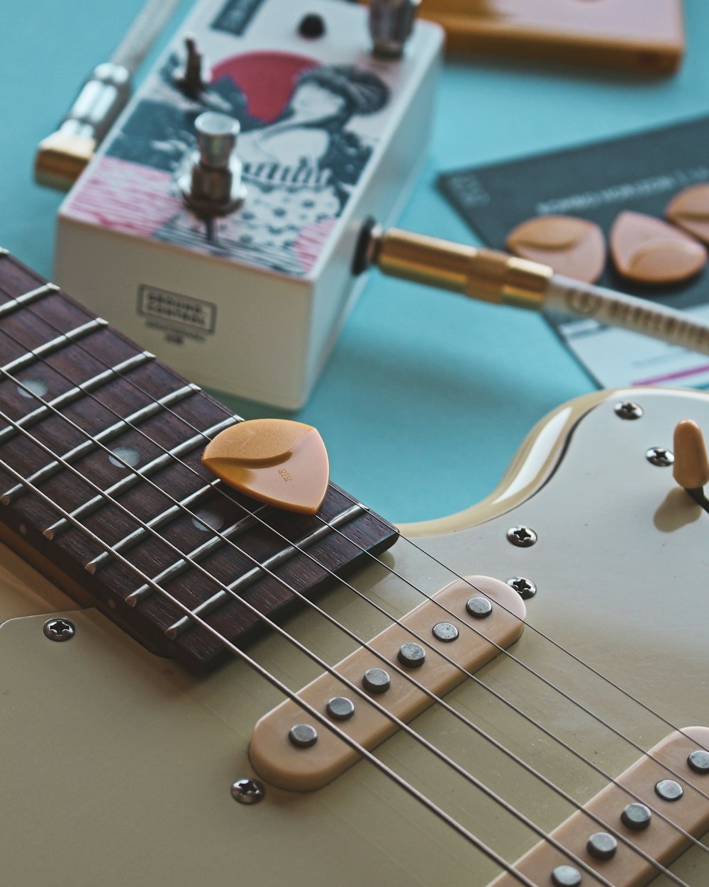 white and brown stratocaster electric guitar