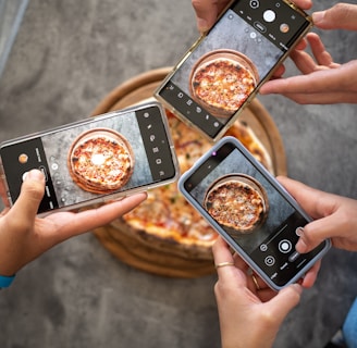 person holding black smartphone taking photo of pizza