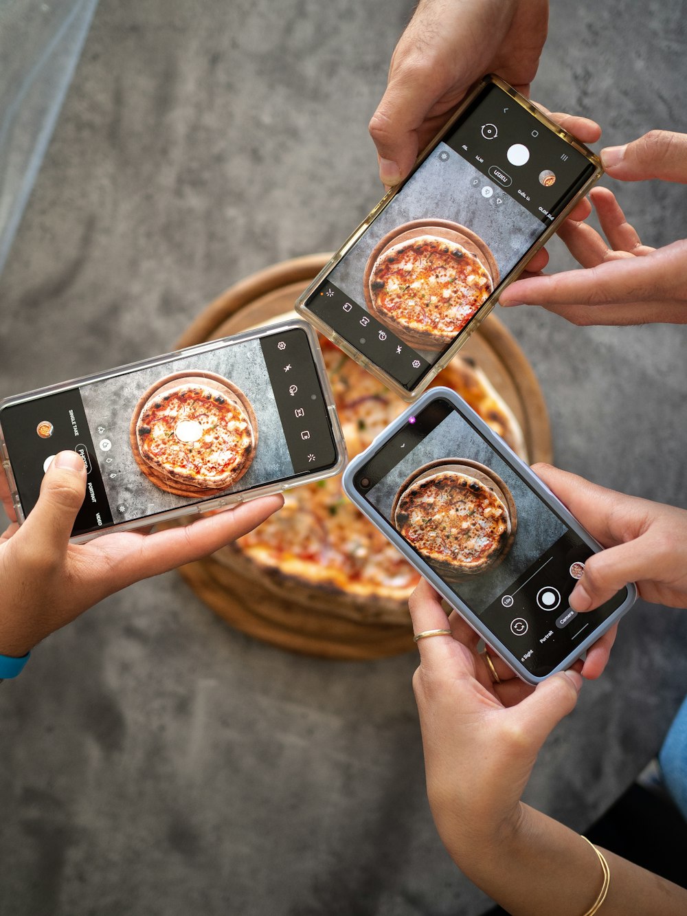 person holding black smartphone taking photo of pizza