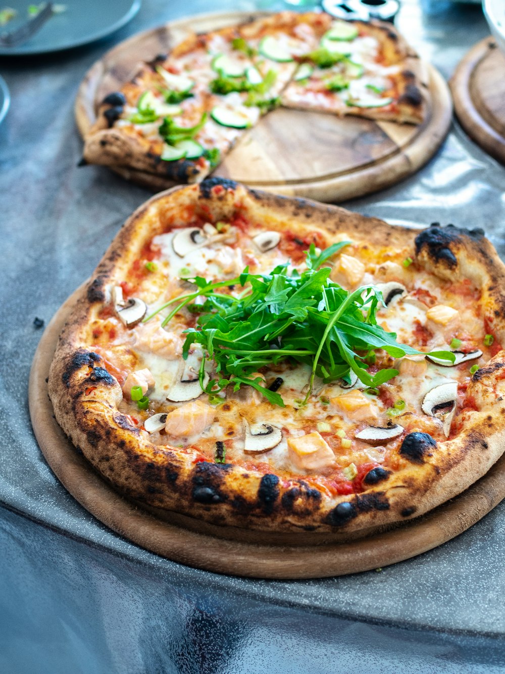 pizza with green leaves on brown wooden table