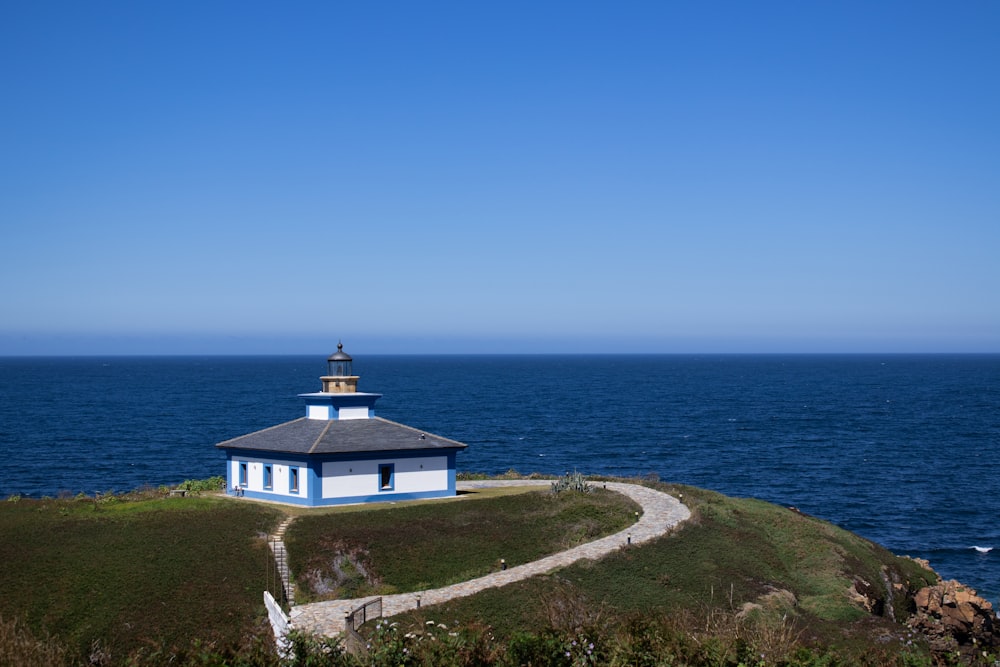 white and black lighthouse near body of water during daytime