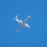 white airplane in mid air during daytime