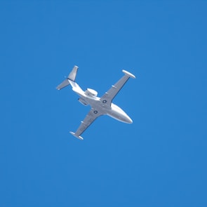 white airplane in mid air during daytime