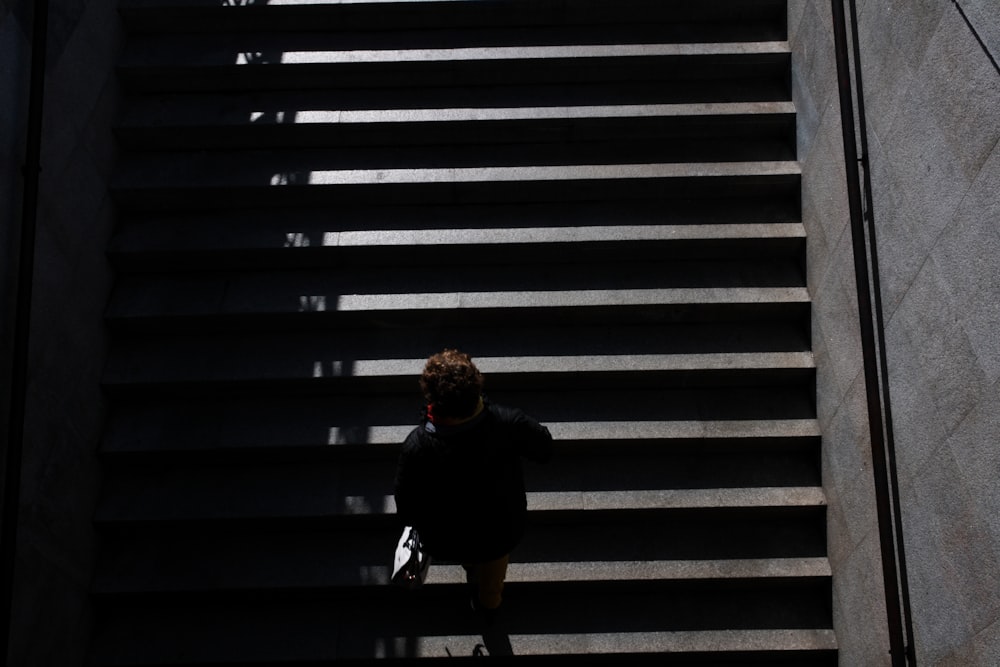 woman in black jacket sitting on stairs