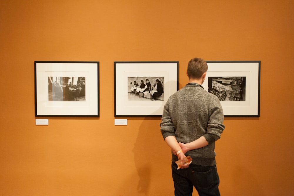 man in gray sweater standing near wall