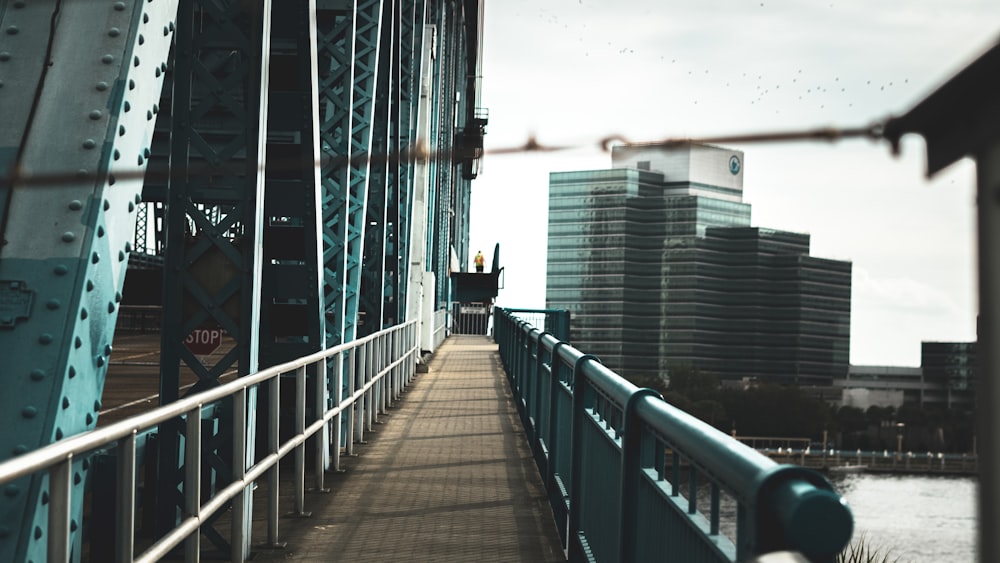 person in black jacket walking on bridge during daytime