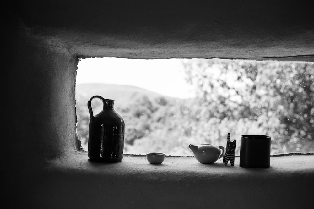 grayscale photo of ceramic teapot and teacup on table