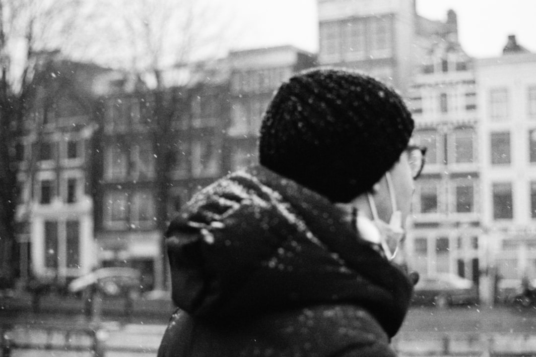 grayscale photo of woman in knit cap and scarf