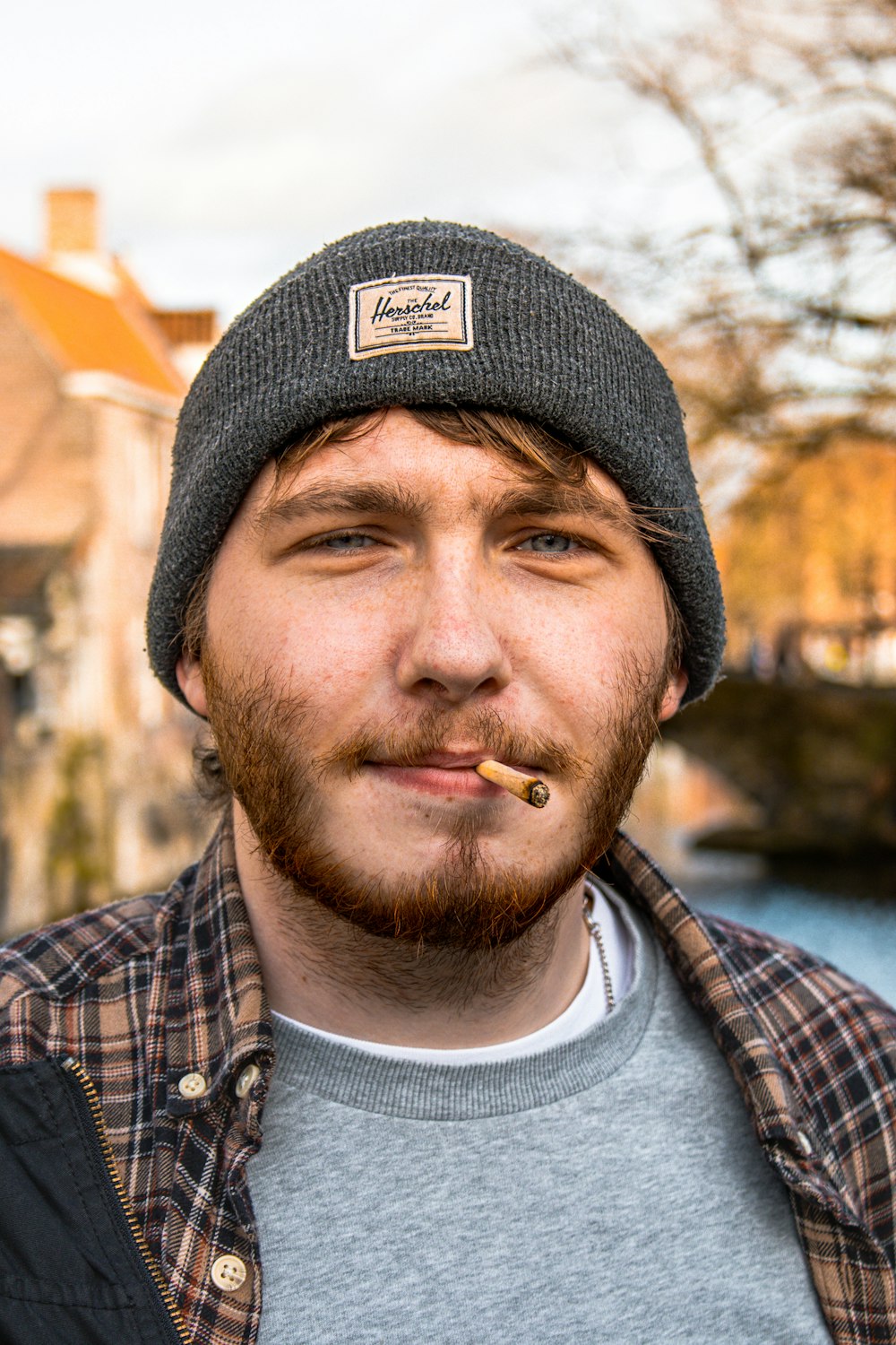 man in black knit cap and blue white and red plaid shirt