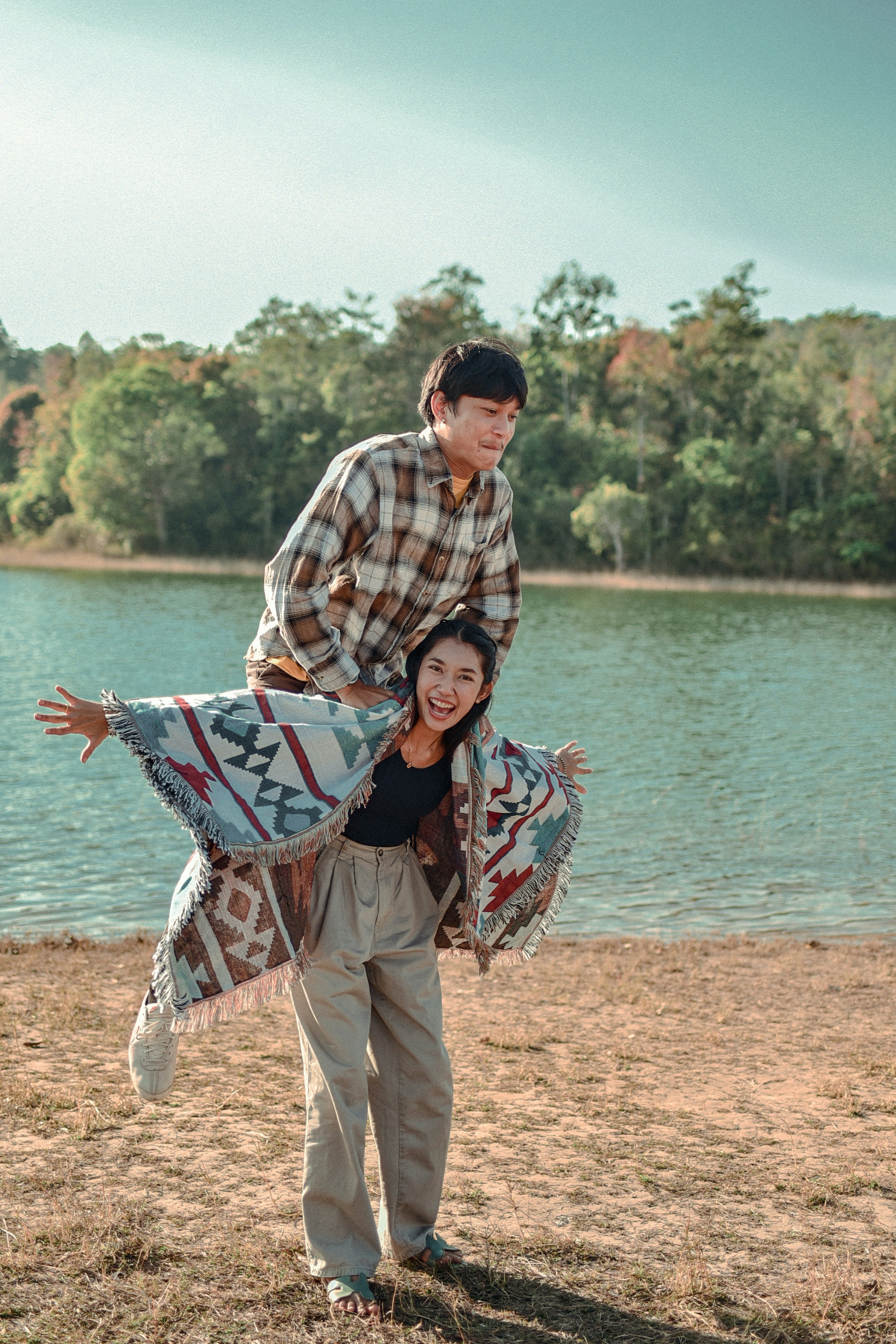 man in white and black plaid dress shirt and brown pants standing on brown sand near near near near near