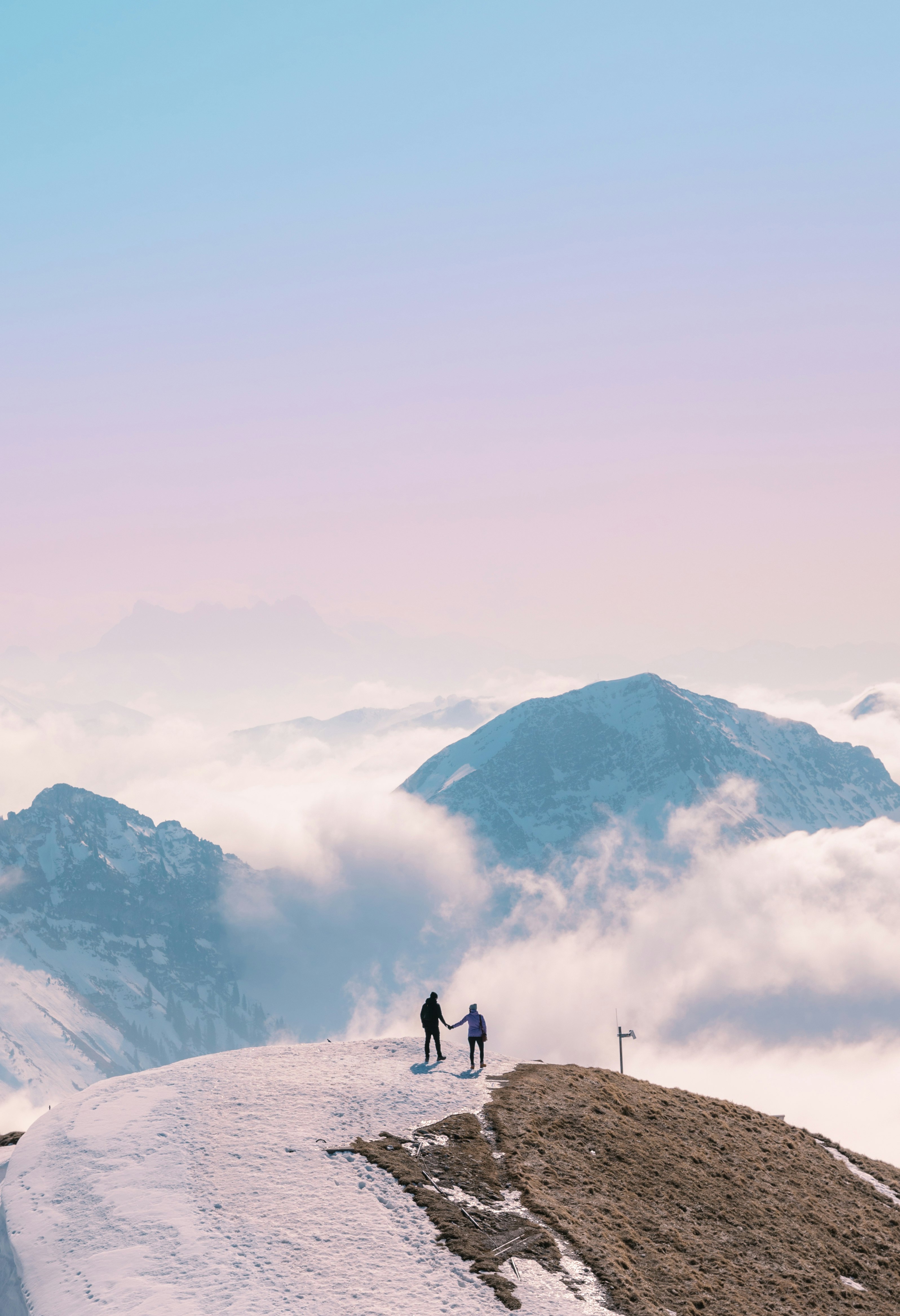 2 people walking on snow covered ground during daytime