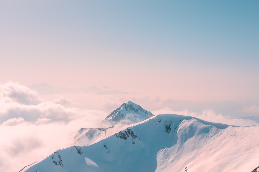 montagne enneigée sous un ciel nuageux pendant la journée