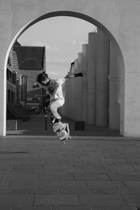 Dynamic shot of a skateboarder mid-air, framed by sharp modern architecture.